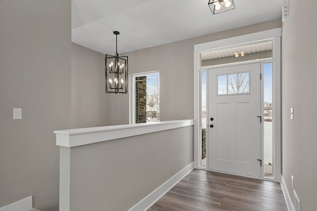 foyer entrance with wood-type flooring and a chandelier