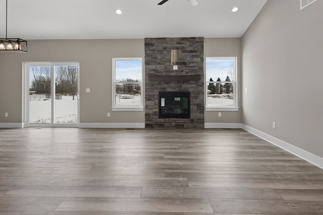 unfurnished living room featuring wood-type flooring, a fireplace, and a healthy amount of sunlight