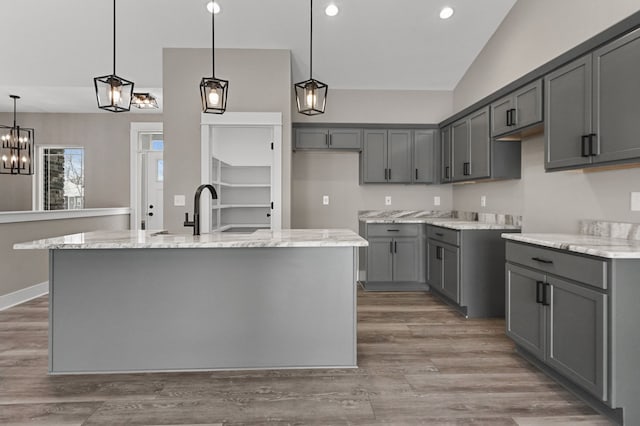 9033 Copper Ridge Dr, Davison, MI 48423 - kitchen featuring gray cabinetry, light stone counters, wood finished floors, decorative light fixtures, and recessed lighting