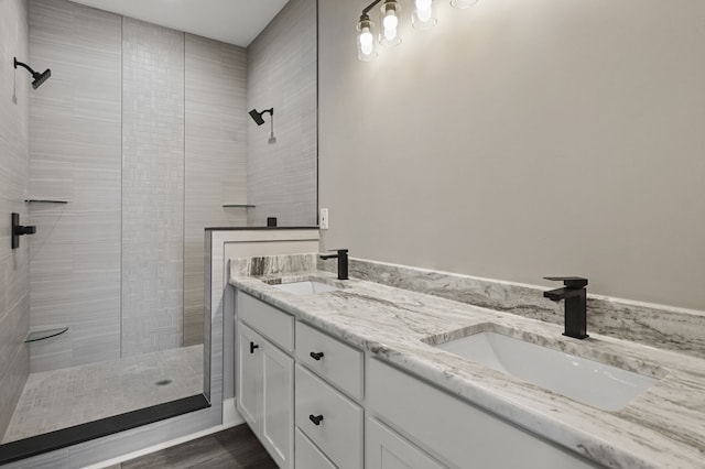 bathroom with vanity, hardwood / wood-style floors, and a tile shower