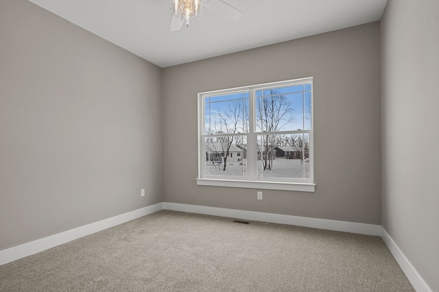 carpeted spare room featuring ceiling fan