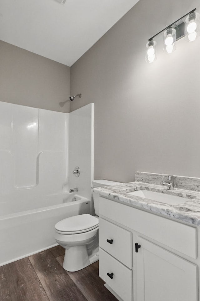 full bathroom with hardwood / wood-style flooring, vanity, toilet, and  shower combination