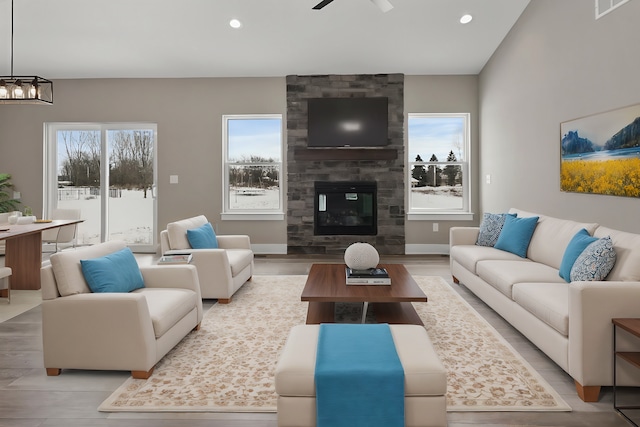 living room with ceiling fan, a fireplace, and light hardwood / wood-style flooring