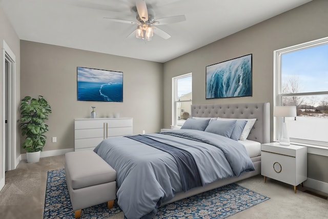 bedroom with multiple windows, light colored carpet, and ceiling fan