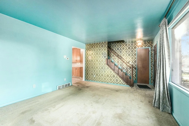 spare room featuring light colored carpet and a wealth of natural light