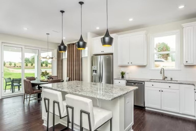 kitchen featuring white cabinetry, appliances with stainless steel finishes, a center island, and sink