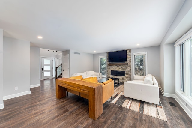 living room with dark wood-type flooring and a fireplace