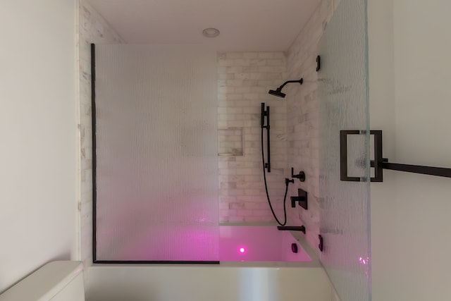 bathroom featuring bath / shower combo with glass door and toilet