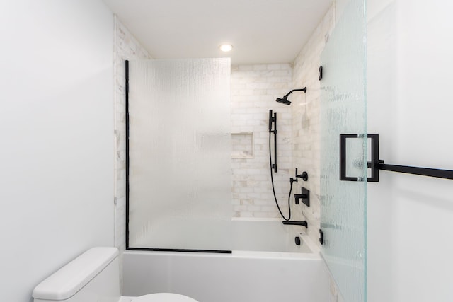 bathroom featuring bath / shower combo with glass door and toilet