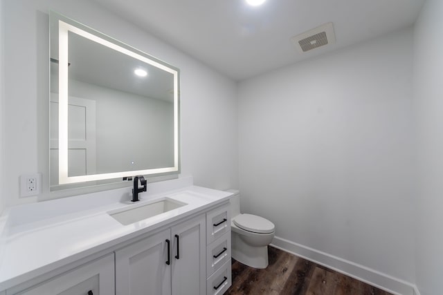 bathroom featuring vanity, hardwood / wood-style floors, and toilet