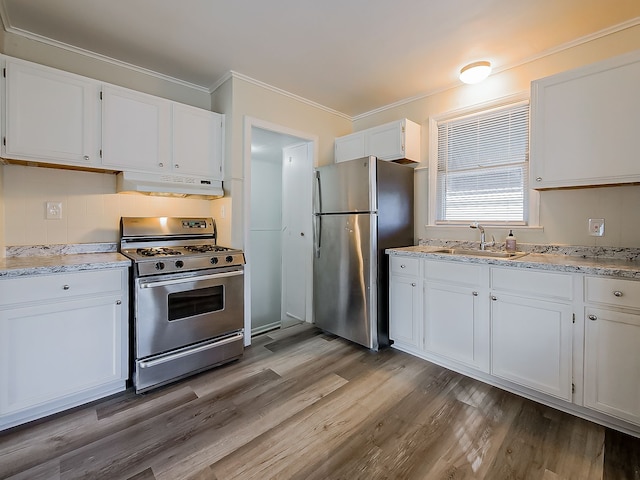 kitchen featuring sink, light wood-type flooring, ornamental molding, appliances with stainless steel finishes, and white cabinetry