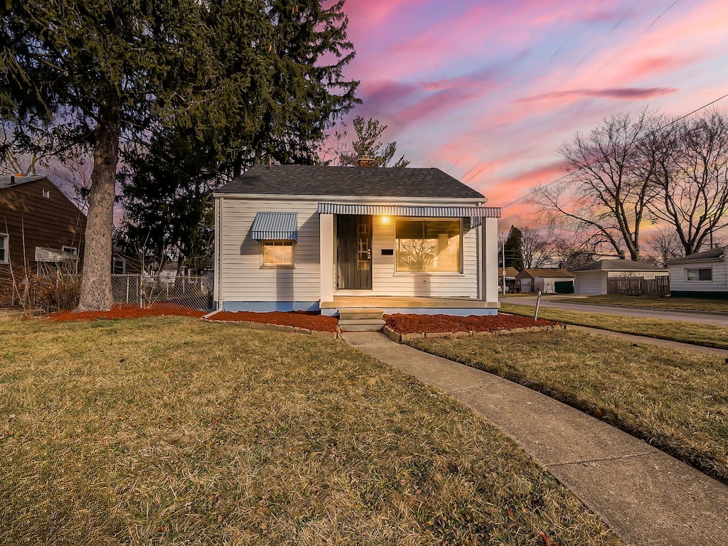 bungalow-style house featuring a lawn