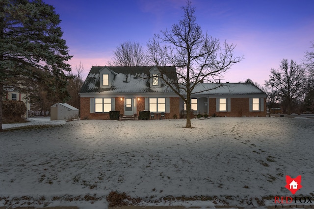 cape cod-style house featuring a storage unit