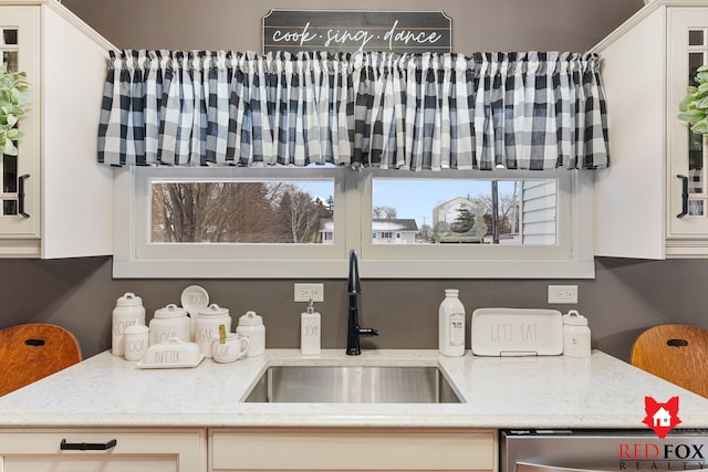 kitchen featuring stainless steel dishwasher, white cabinets, and sink