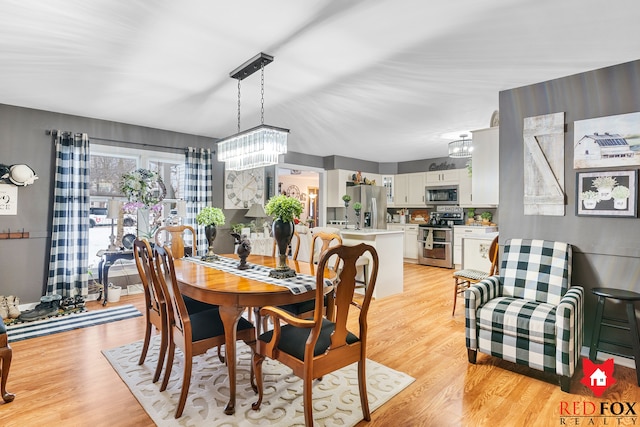 dining area featuring light hardwood / wood-style floors and an inviting chandelier