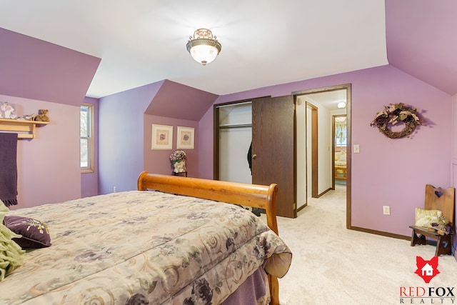 carpeted bedroom with lofted ceiling and a closet