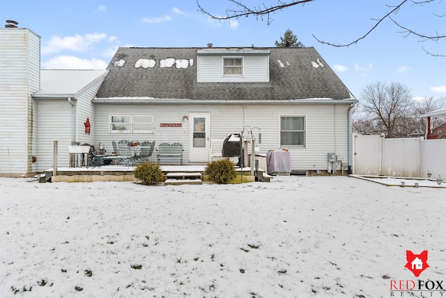 view of snow covered back of property