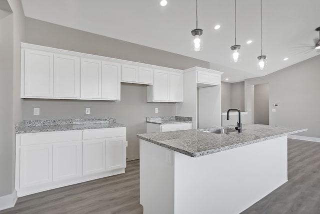 kitchen with white cabinetry, an island with sink, sink, and pendant lighting