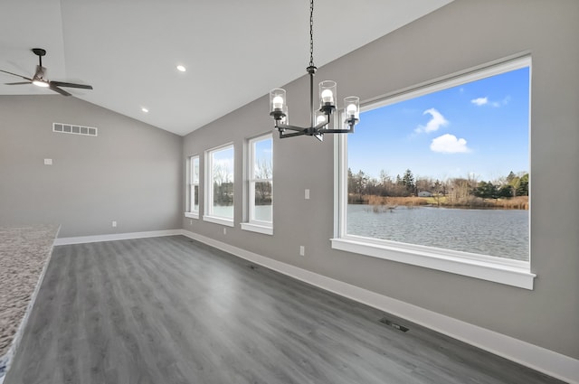 unfurnished dining area featuring vaulted ceiling, a water view, dark hardwood / wood-style floors, and ceiling fan with notable chandelier