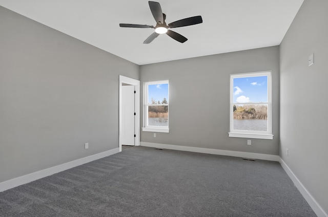 carpeted empty room featuring ceiling fan and plenty of natural light