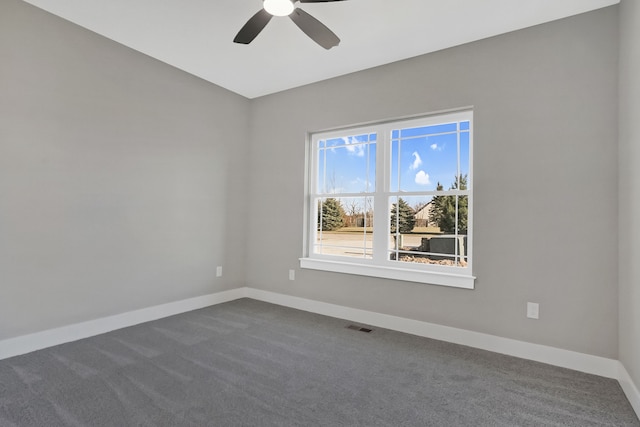 empty room featuring dark carpet and ceiling fan