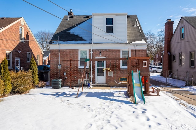 snow covered property featuring a playground