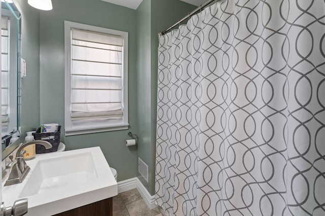 bathroom featuring tile patterned flooring, vanity, curtained shower, and toilet