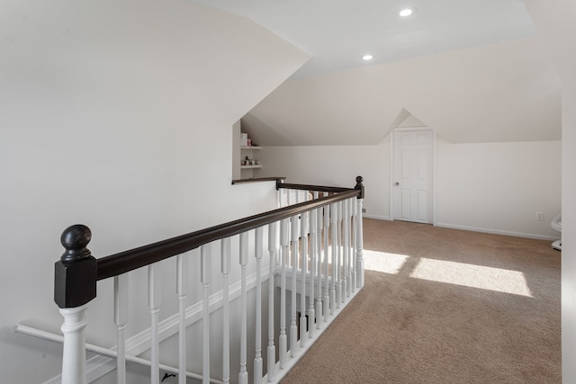 hall with lofted ceiling and carpet