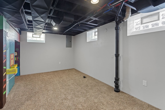 basement with carpet floors, a healthy amount of sunlight, and electric panel