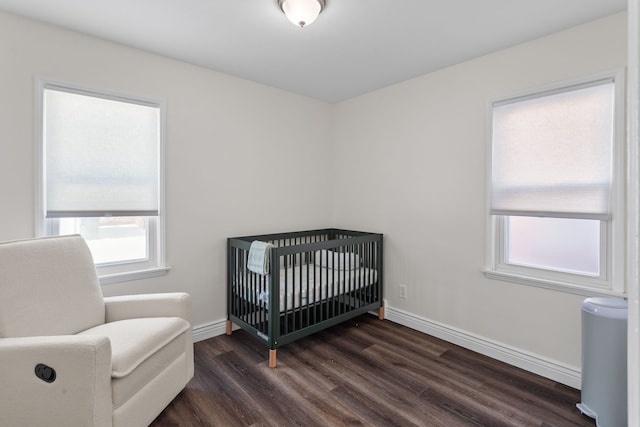 bedroom featuring a crib and dark hardwood / wood-style floors