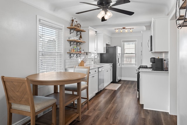 kitchen featuring sink, dark wood-type flooring, white cabinetry, stainless steel appliances, and decorative backsplash