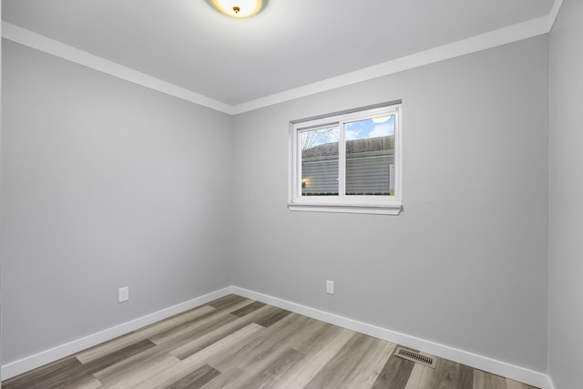 unfurnished room featuring light wood-type flooring and ornamental molding