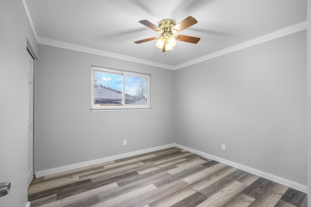 spare room featuring light wood-type flooring, ceiling fan, and crown molding