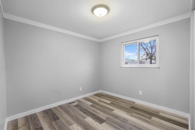 empty room with light wood-type flooring and ornamental molding