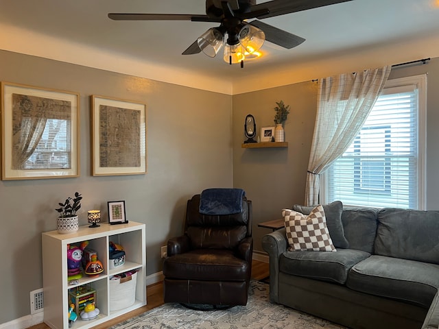 living room with light hardwood / wood-style flooring and ceiling fan