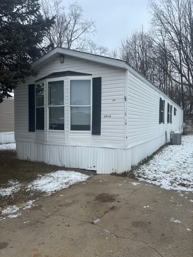 view of snowy exterior featuring central air condition unit