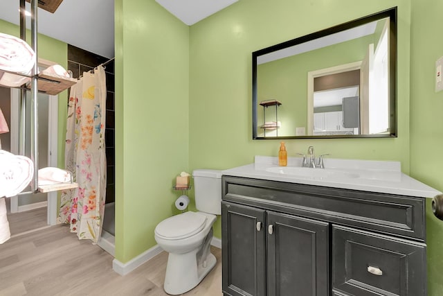 bathroom featuring a shower with shower curtain, hardwood / wood-style floors, vanity, and toilet