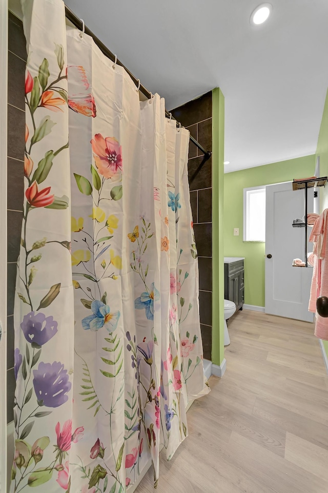 bathroom featuring hardwood / wood-style floors, vanity, and walk in shower