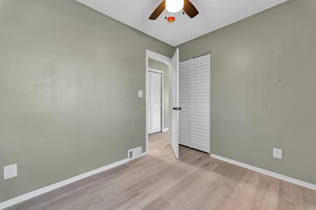 unfurnished bedroom with light wood-type flooring, a closet, and ceiling fan