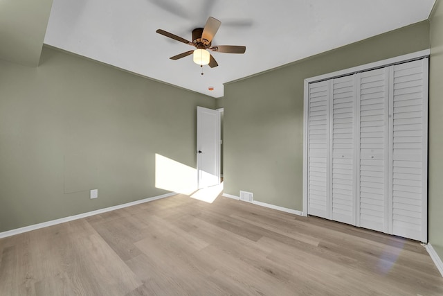 unfurnished bedroom with light wood-type flooring, a closet, and ceiling fan