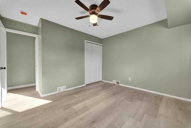 unfurnished bedroom featuring ceiling fan, light hardwood / wood-style floors, and a closet