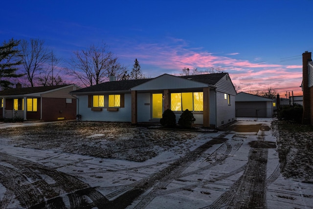 back house at dusk featuring a garage and an outdoor structure