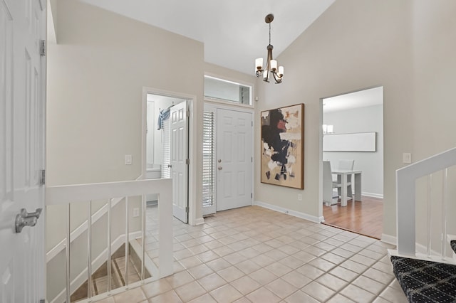 tiled foyer entrance featuring vaulted ceiling and an inviting chandelier