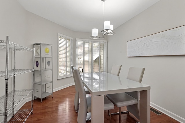 dining space featuring dark hardwood / wood-style floors and a notable chandelier