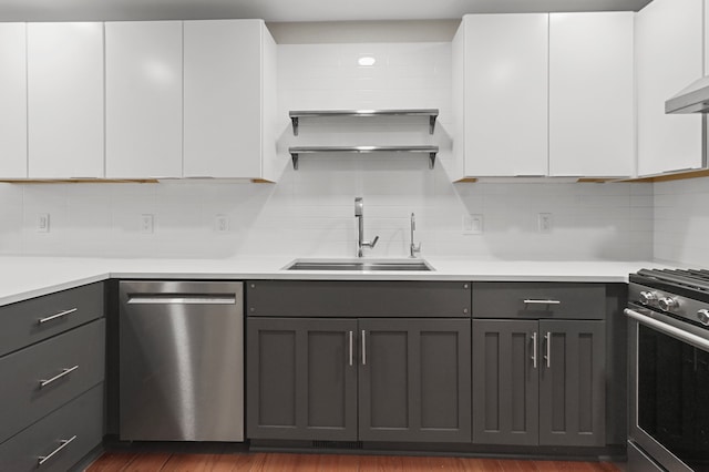 kitchen with appliances with stainless steel finishes, white cabinetry, and sink