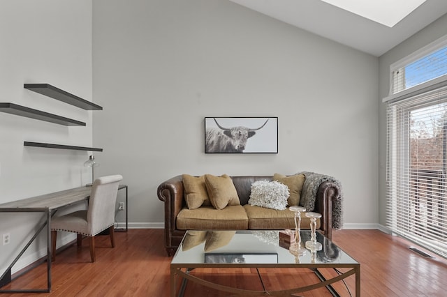 living room featuring wood-type flooring and vaulted ceiling