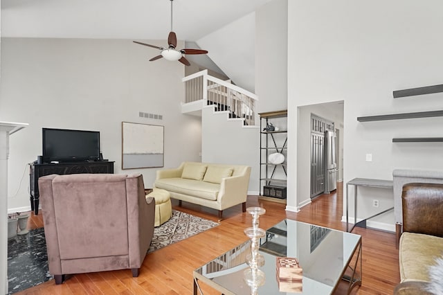 living room featuring ceiling fan, high vaulted ceiling, and hardwood / wood-style flooring