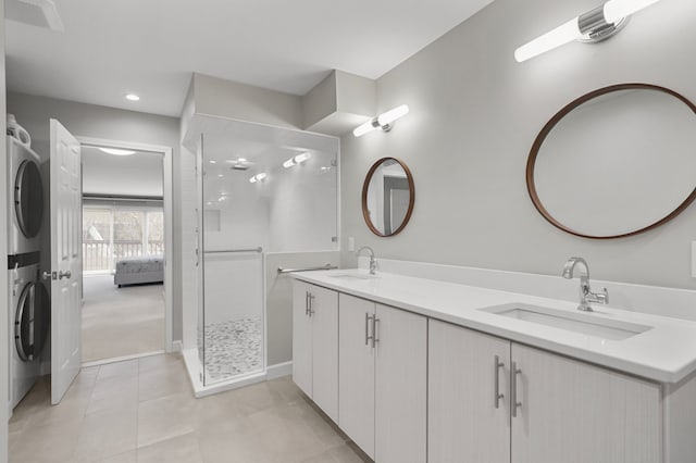 bathroom with tiled shower, vanity, stacked washer / drying machine, and tile patterned flooring