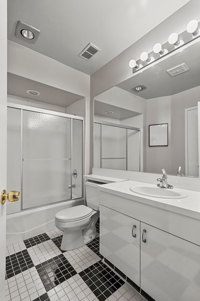 full bathroom with tile patterned flooring, vanity, bath / shower combo with glass door, and toilet