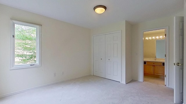 5059 Pheasant Cv, West Bloomfield, MI 48323 - unfurnished bedroom featuring a closet, baseboards, ensuite bath, a sink, and light colored carpet